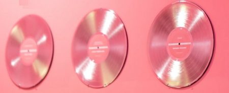 ピンクの壁に飾られた3つのDVDディスク