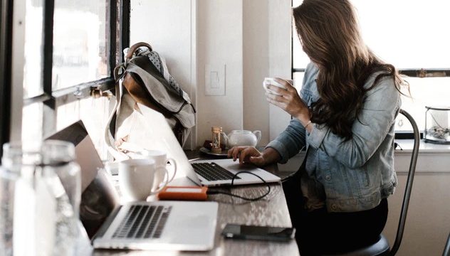 カフェでノートパソコンを使った作業をする女性